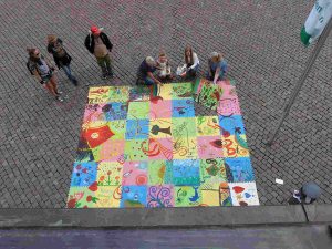 Brigitta Arnold präsentiert das Puzzle der Pirnaer Kinder vor dem Rathaus